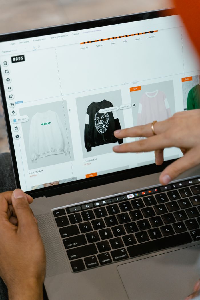 about-01 Gros plan sur des mains qui interagissent avec un site d'achat sur l'écran d'un ordinateur portable à l'intérieur.